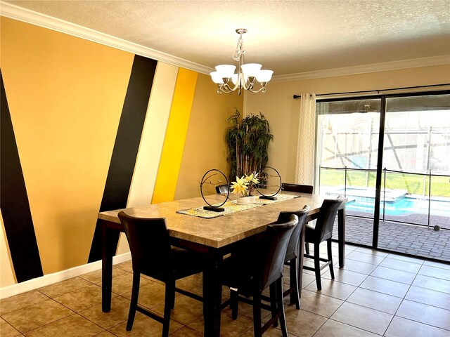 dining space featuring a textured ceiling, ornamental molding, tile patterned floors, and a notable chandelier