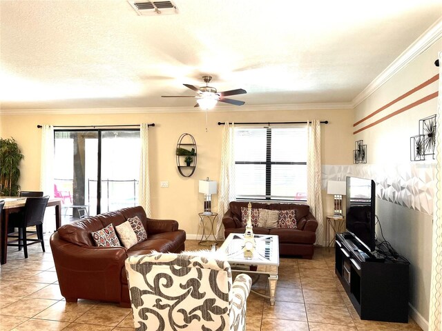 tiled living room featuring ornamental molding, ceiling fan, and a wealth of natural light