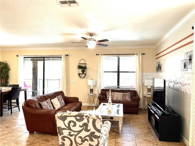 living area featuring baseboards, ornamental molding, light tile patterned floors, a ceiling fan, and visible vents