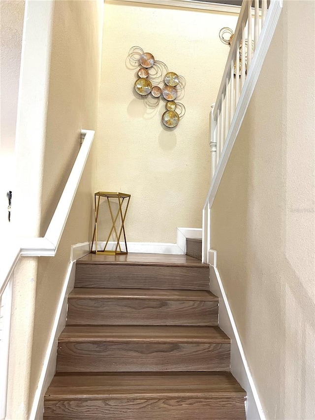 staircase with wood finished floors and baseboards