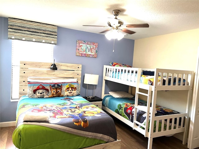 bedroom with ceiling fan, baseboards, wood finished floors, and a textured ceiling