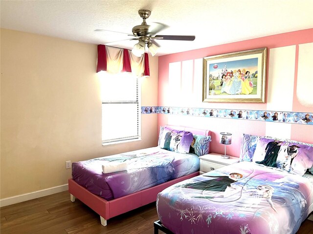 bedroom with a textured ceiling, hardwood / wood-style floors, and ceiling fan