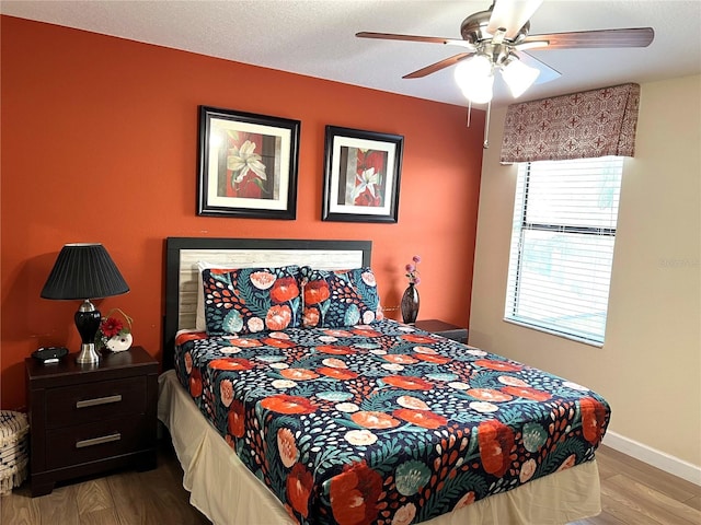 bedroom featuring wood finished floors, ceiling fan, and baseboards