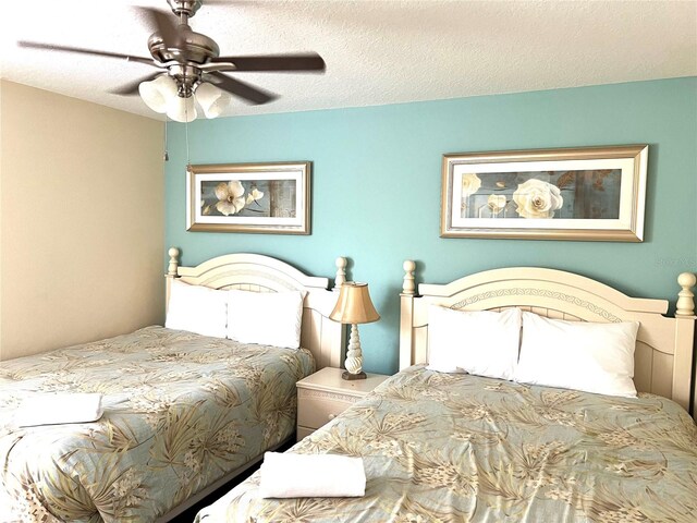 bedroom with ceiling fan and a textured ceiling