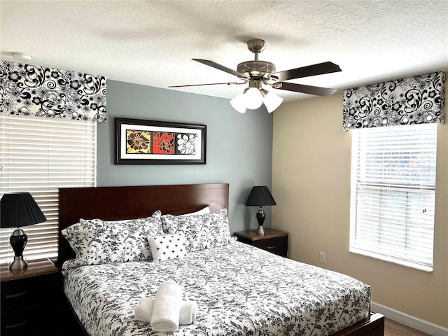bedroom featuring ceiling fan, baseboards, and a textured ceiling
