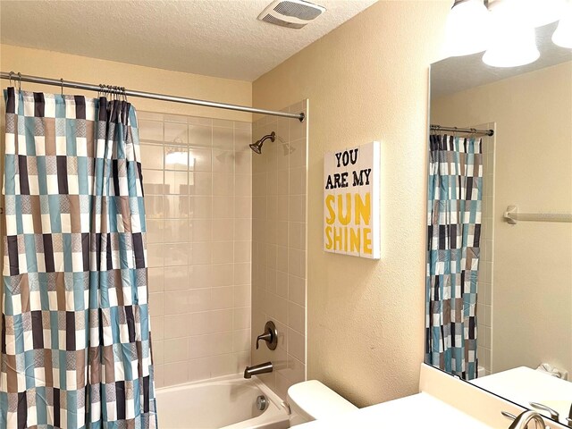 bathroom with a textured ceiling, shower / bath combo, and toilet