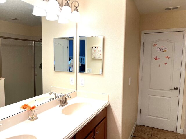 bathroom with vanity, tile patterned floors, and a shower with shower door