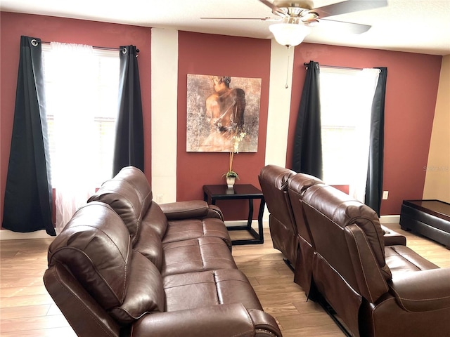 living area with light wood finished floors, baseboards, and ceiling fan
