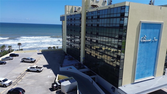 exterior space featuring uncovered parking, a view of the beach, and a water view