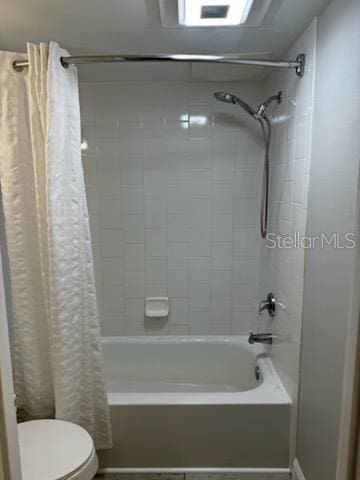 bathroom featuring shower / bath combo with shower curtain and toilet