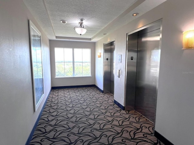 corridor featuring carpet, a textured ceiling, and elevator