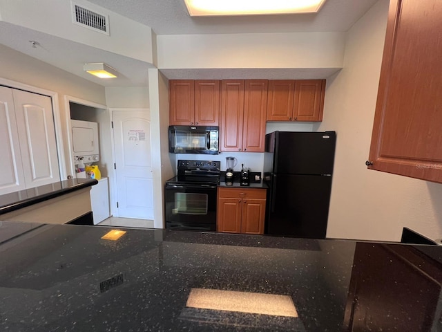 kitchen with black appliances and dark stone counters