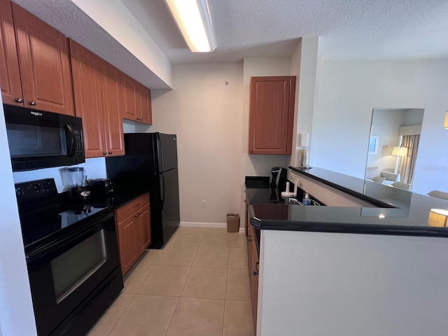 kitchen with a textured ceiling, black appliances, light tile patterned floors, and kitchen peninsula