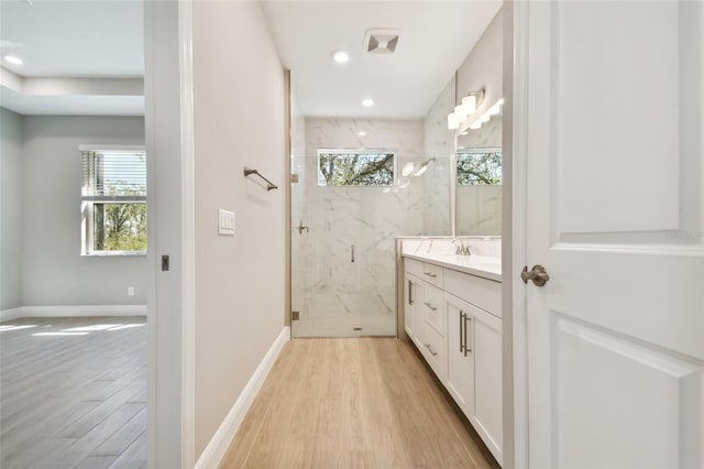 bathroom with vanity, an enclosed shower, hardwood / wood-style flooring, and a wealth of natural light