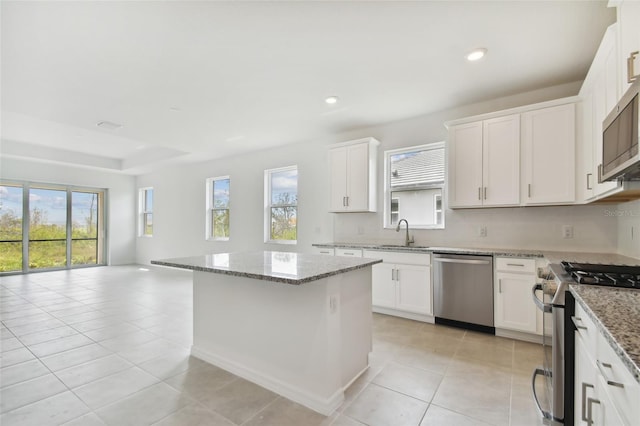 kitchen with white cabinets, plenty of natural light, a kitchen island, and appliances with stainless steel finishes