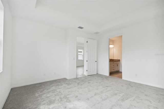 unfurnished bedroom with light colored carpet and ensuite bath