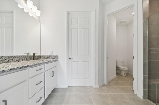 bathroom featuring vanity, tile patterned floors, and toilet