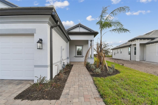 doorway to property featuring a yard and a garage