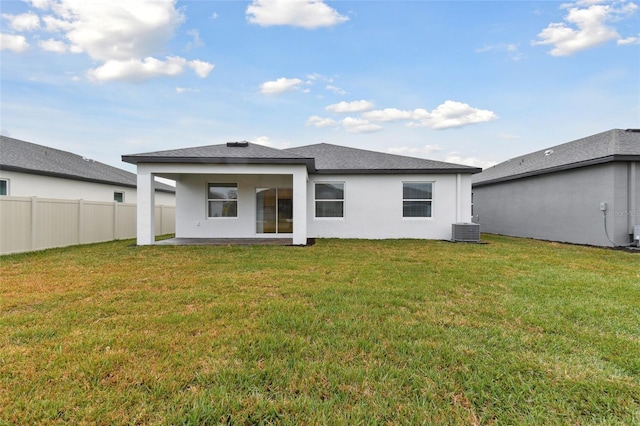 rear view of house with a yard, central AC, and a patio area