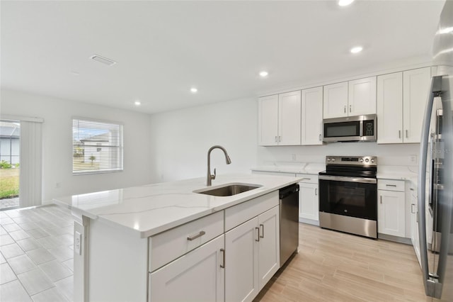 kitchen featuring white cabinetry, an island with sink, appliances with stainless steel finishes, and sink