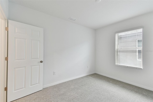 carpeted spare room featuring plenty of natural light