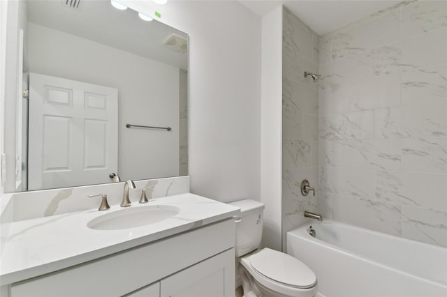 full bathroom featuring tiled shower / bath, vanity, and toilet