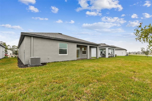 back of house with central AC unit and a lawn