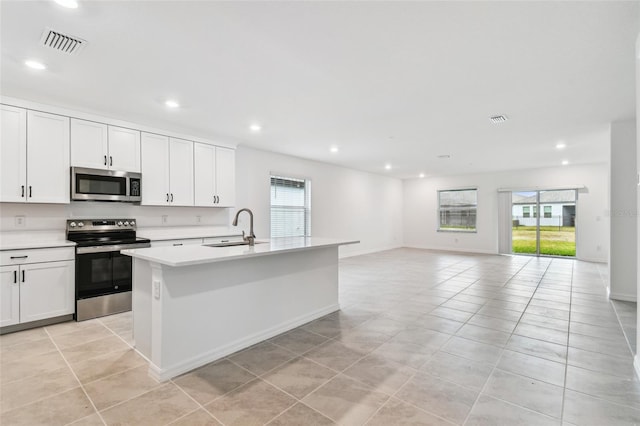 kitchen featuring white cabinetry, appliances with stainless steel finishes, sink, and a kitchen island with sink