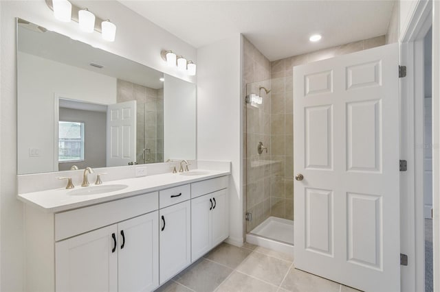 bathroom with an enclosed shower, vanity, and tile patterned floors