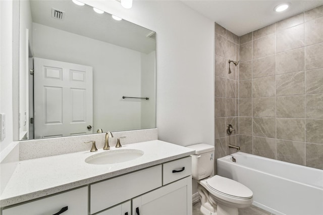 full bathroom featuring tiled shower / bath, vanity, and toilet