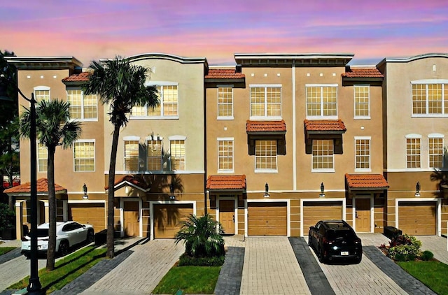5002 Tideview Cir Unit 3, Orlando, FL 32819 - view of front of house featuring a tiled roof, an attached garage, driveway, and stucco siding