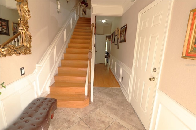 5002 Tideview Cir Unit 3, Orlando, FL 32819 - stairway featuring crown molding, wainscoting, tile patterned flooring, and a decorative wall