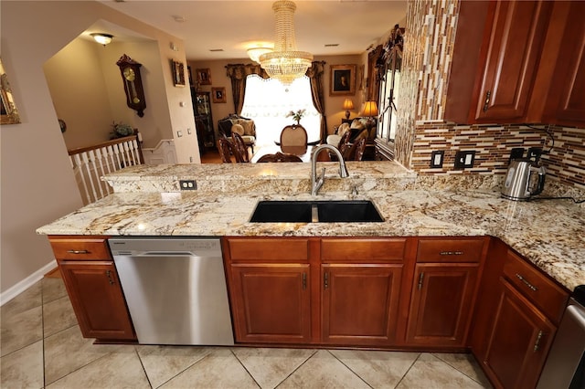 5002 Tideview Cir Unit 3, Orlando, FL 32819 - kitchen featuring light stone counters, an inviting chandelier, a sink, dishwasher, and a peninsula