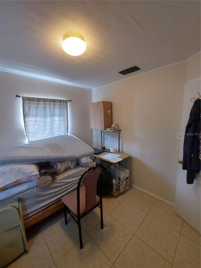 bedroom with ornamental molding, light tile patterned flooring, and a textured ceiling