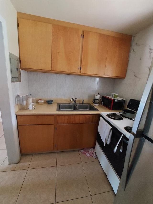 kitchen with white range with electric stovetop, electric panel, sink, and light tile patterned floors