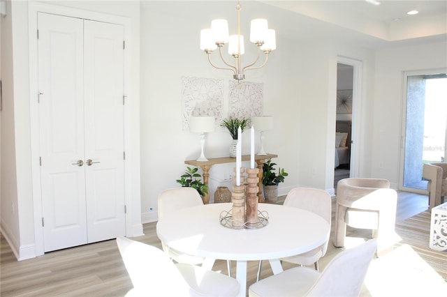 dining space featuring an inviting chandelier and light wood-type flooring