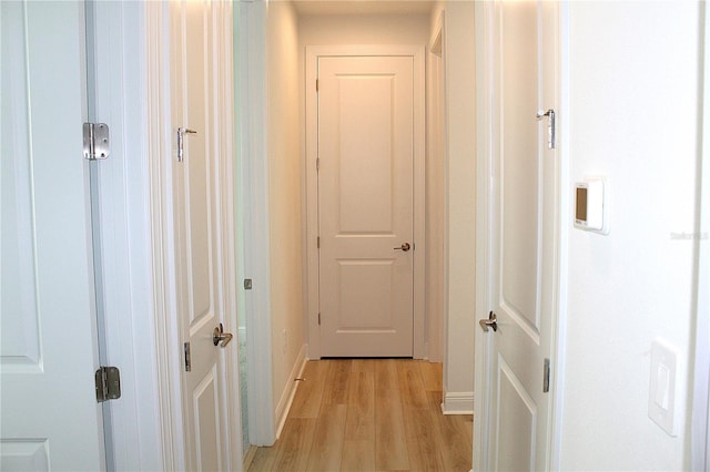 corridor with light hardwood / wood-style floors