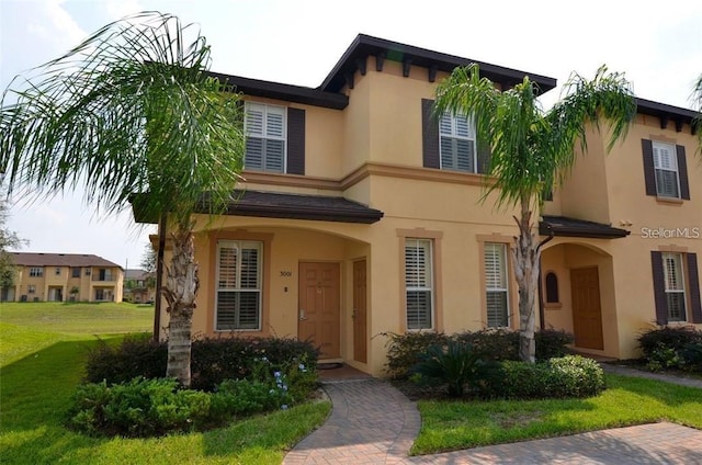 view of front facade featuring stucco siding and a front lawn