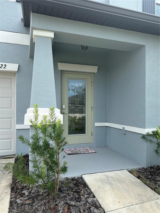 entrance to property featuring stucco siding