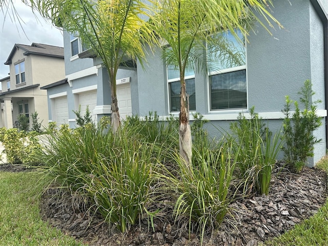 view of home's exterior with stucco siding and a garage