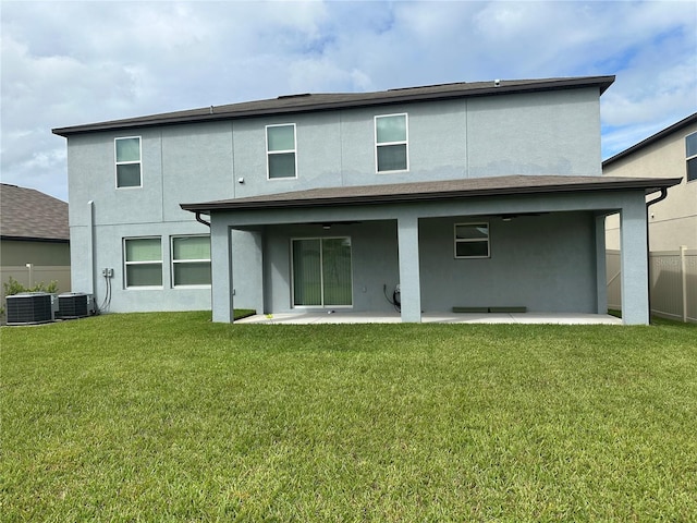 rear view of property with stucco siding, a patio, a lawn, and fence