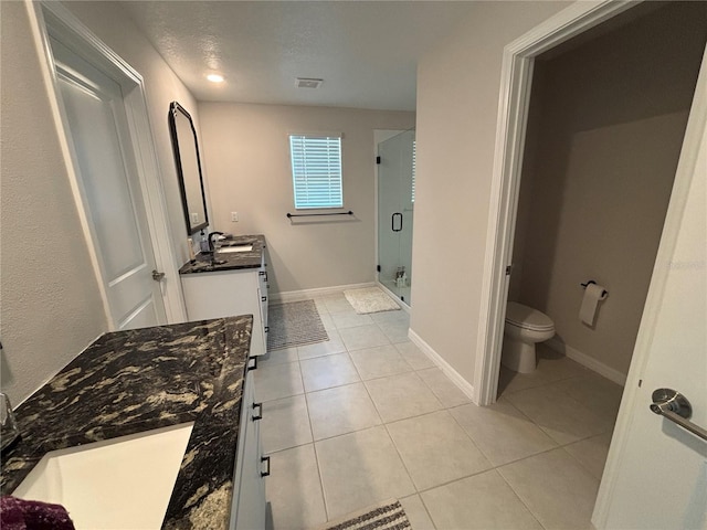 full bathroom with a shower stall, baseboards, toilet, tile patterned floors, and vanity