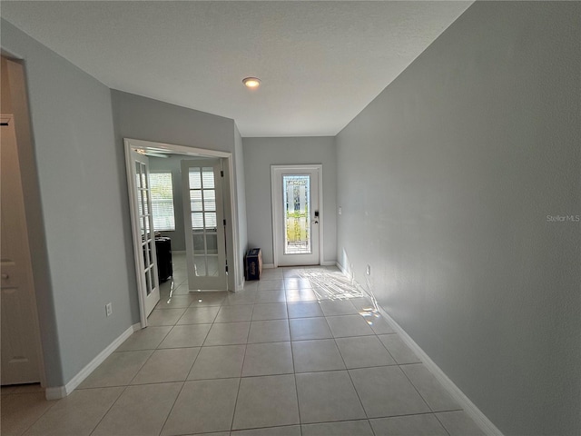 foyer entrance with light tile patterned floors and baseboards