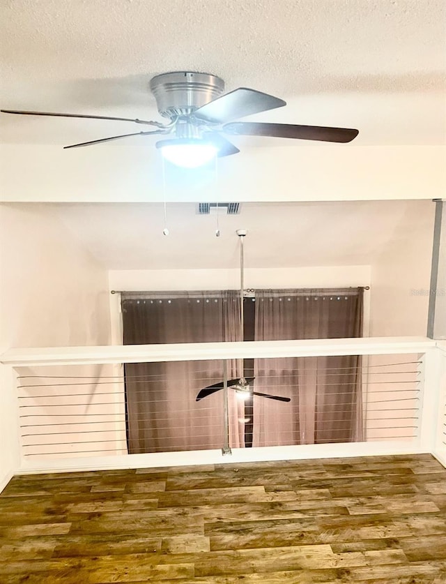 details with visible vents, a textured ceiling, wood finished floors, and a ceiling fan