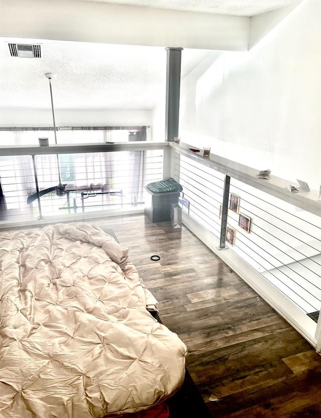 unfurnished bedroom featuring a textured ceiling, wood finished floors, and visible vents