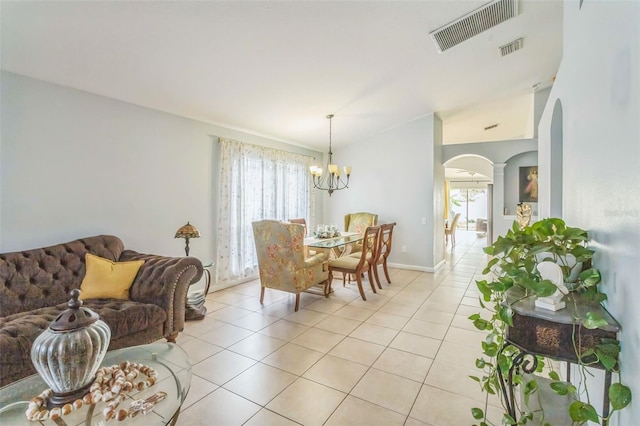 tiled dining area with lofted ceiling and a chandelier