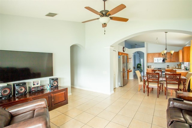 living room with high vaulted ceiling, light tile patterned floors, and ceiling fan with notable chandelier