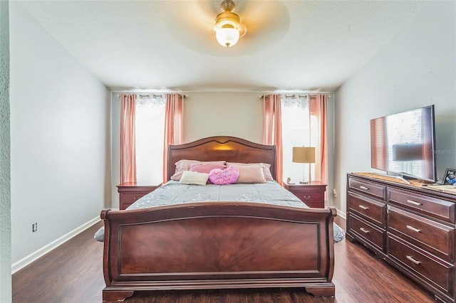 bedroom with ceiling fan, multiple windows, and dark hardwood / wood-style floors