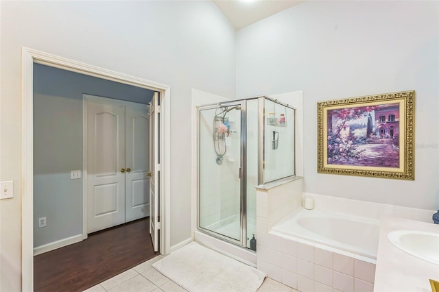 bathroom featuring vanity, a towering ceiling, tile patterned flooring, and separate shower and tub