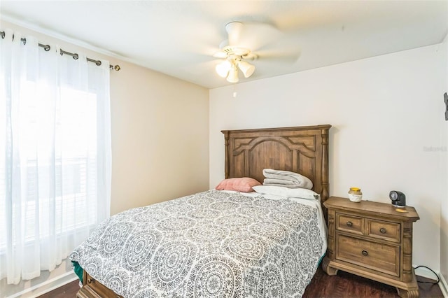 bedroom with dark hardwood / wood-style flooring and ceiling fan